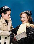 1940s TEEN COUPLE WEARING WINTER HATS GLOVES COATS GIRL SMILING CARRYING SCHOOL BOOKS