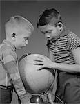 1960s TWO BOYS STUDYING EARTH GLOBE