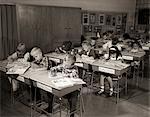 1960s ELEMENTARY CLASSROOM CHILDREN AT DESKS WRITING STUDYING