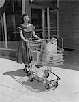 1950s SMILING WOMAN PUSHING GROCERY CART OUT OF SUPERMARKET