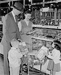 FAMILLE DES ANNÉES 1950 DE 4 À L'INTÉRIEUR DU CHARIOT POUSSER SUPERMARCHÉ PÈRE MÈRE 2 ENFANTS