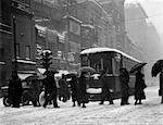 1920s - 1930s CROWD CARRYING UMBRELLAS CROSSING STREET IN FRONT OF STREET CAR TROLLEY DURING SNOWSTORM