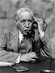 1920s - 1930s BUSINESSMAN ON CANDLESTICK TELEPHONE LOOKING SURPRISED AND ALARMED