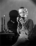 1930s WOMAN TALKING ON TELEPHONE CASTING SHADOW ON WALL