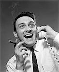 1950s - 1960s EXCITED MAN TALKING ON TELEPHONE GRINNING SMOKING CIGAR INDOOR