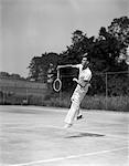 1930s MAN PLAYING TENNIS JUMPING MID AIR ACTION