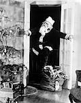 1920s1930s SANTA CLAUS SNEAKING INTO LIVING ROOM THROUGH DOUBLE DOORS