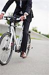 Businessman riding bicycle in urban park