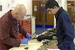 Teacher helping student with car parts