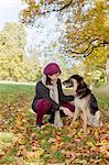 Souriant femme caresser chien dans le parc