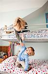 Young boys playfighting on their bunk bed
