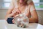 Senior Woman sparen Geld im Sparschwein