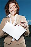 Businesswoman ripping paper outdoors