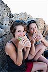 Hikers eating sandwiches on rocks