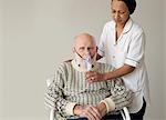 Caretaker helping older man with oxygen
