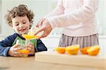 Mother pouring orange juice for son