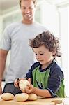 Boy peeling potatoes in kitchen