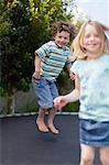 Smiling children jumping on trampoline