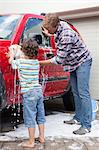 Father and son washing car together