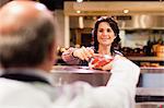 Woman buying meat from butcher