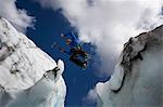 Hiker jumping in between glaciers