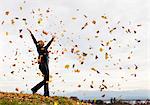 Woman playing in fall leaves