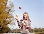 Woman juggling apples outdoors