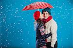 Souriant couple s'embrassant dans la neige