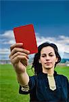 Woman holding red card on soccer pitch