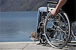 Man in wheelchair sitting by water