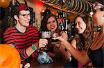 Young friends toasting drinks in bar