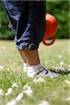 Jambes et les pieds de bébé fille debout sur l'herbe dans le jardin, Farnham, Angleterre