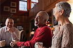 Mature friends laughing together in living room