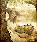 Beautiful redhead girl with fruits in basket at garden.