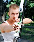 young man with a bow and arrows in the woods