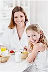 Mother and daughter eating breakfast in the kitchen