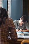 Portrait of a student writing an essay in the library