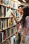 Portrait of young students choosing a book in a library