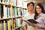 Young students holding a book in a library