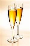 Two full champagne flutes with sparkling wine