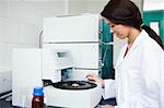 Cute scientist using a centrifuge in a laboratory