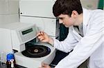 Young chemist using a centrifuge in a laboratory