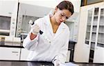 Serious scientist pouring a liquid in an Erlenmeyer flask in a laboratory