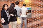 Impatient woman queuing at an ATM