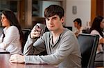 Young man having a coffee while looking at the camera