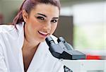 Close up of a scientist posing with a microscope in a laboratory