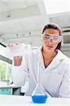 Portrait of a female science student pouring liquid in a laboratory