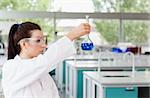 Brunette scientist looking at a flask in a laboratory