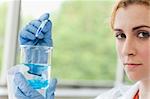 Scientist dropping liquid in a beaker in a laboratory