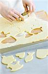 Woman using cookie cutter and baking homemade cookies